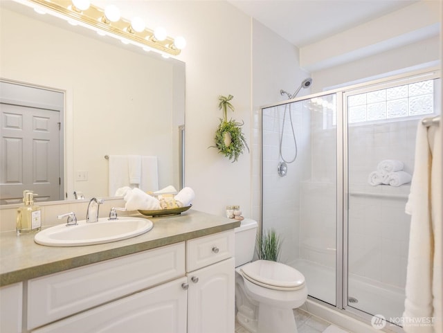 full bathroom featuring a stall shower, vanity, and toilet