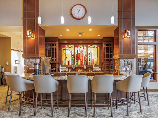 kitchen featuring freestanding refrigerator, visible vents, a peninsula, and a high ceiling