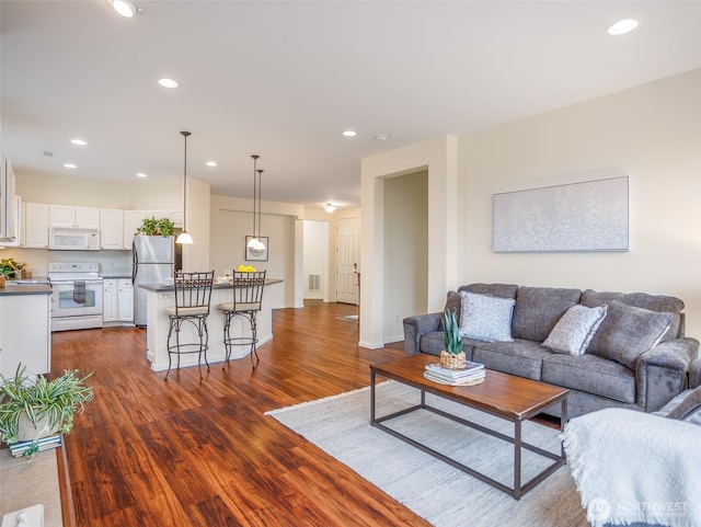 living room featuring baseboards, dark wood-type flooring, and recessed lighting