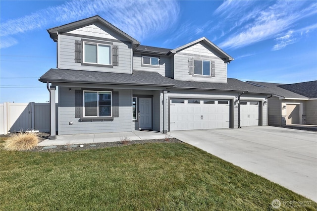 view of front of property with a front lawn, fence, driveway, and an attached garage