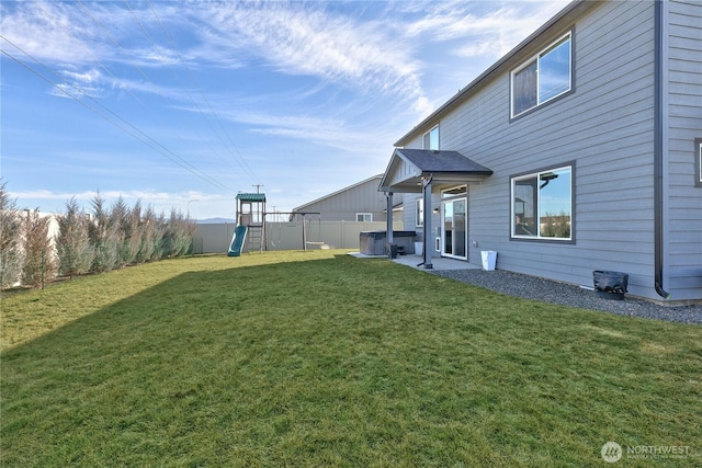 view of yard featuring a patio area, a playground, and a fenced backyard