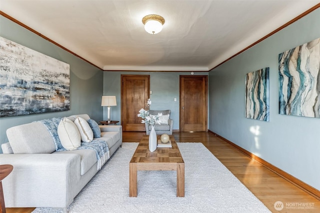 living area featuring crown molding, baseboards, and wood finished floors