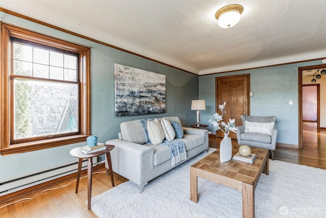 living room with baseboards, crown molding, a baseboard heating unit, and wood finished floors