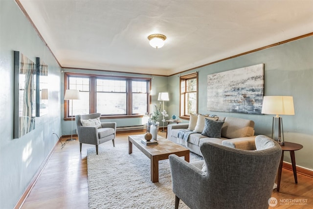 living area with ornamental molding, baseboard heating, baseboards, and wood finished floors