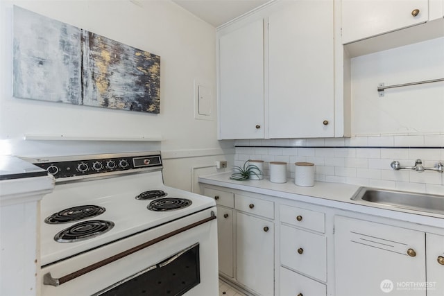 kitchen with white electric range, a sink, white cabinetry, light countertops, and tasteful backsplash