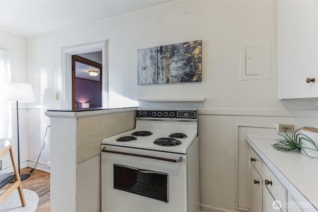 kitchen with electric panel, white cabinets, light wood-style flooring, and white electric range oven