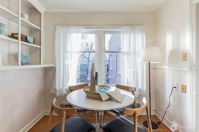 dining space with baseboards and wood finished floors