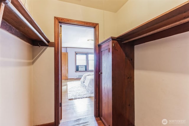 spacious closet featuring cooling unit and wood finished floors