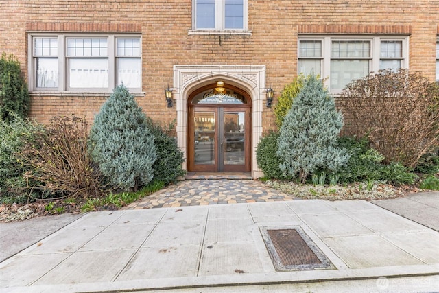 entrance to property featuring french doors and brick siding