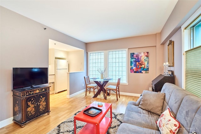 living room with light wood-type flooring and baseboards