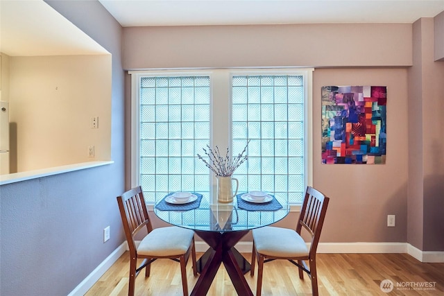 dining area featuring light wood-type flooring and baseboards