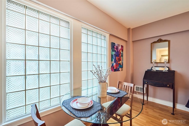 dining room featuring plenty of natural light, light wood-type flooring, visible vents, and baseboards