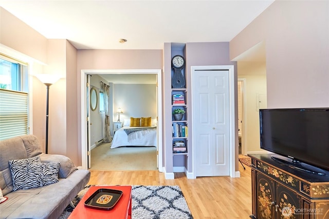 bedroom featuring a closet, baseboards, and light wood finished floors