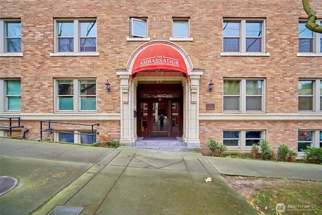 view of exterior entry featuring brick siding