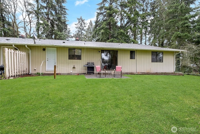 rear view of property featuring a chimney, a patio, and a yard