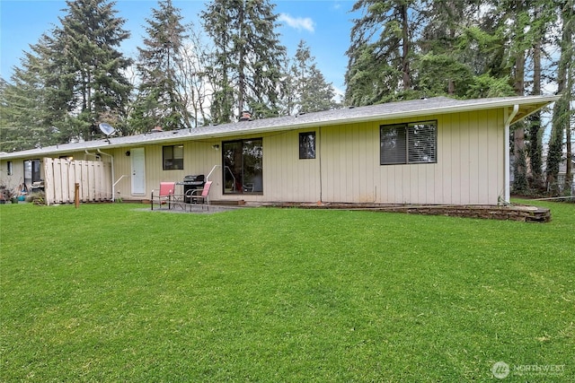 rear view of property featuring a lawn and a patio area