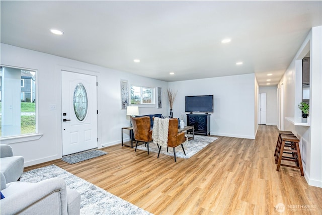 foyer featuring light wood-type flooring, baseboards, a wealth of natural light, and recessed lighting