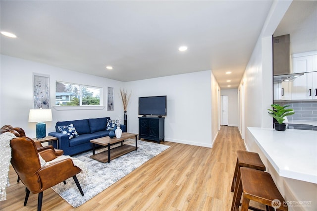 living room featuring recessed lighting, light wood-style flooring, and baseboards