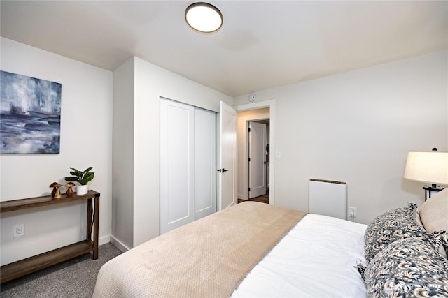 carpeted bedroom with a closet and baseboards