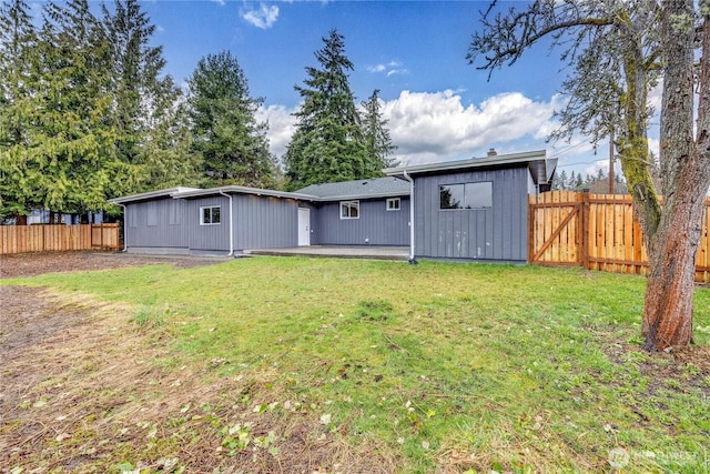 rear view of property featuring fence private yard and a yard