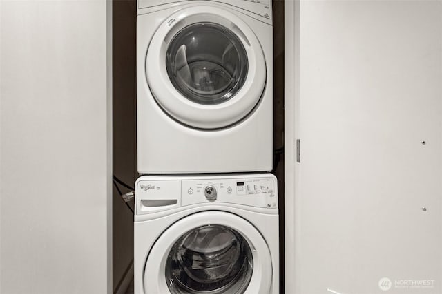 washroom featuring stacked washer / drying machine