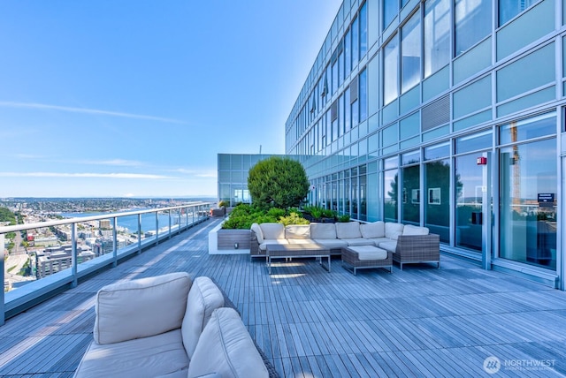 deck with outdoor lounge area, a water view, and a city view