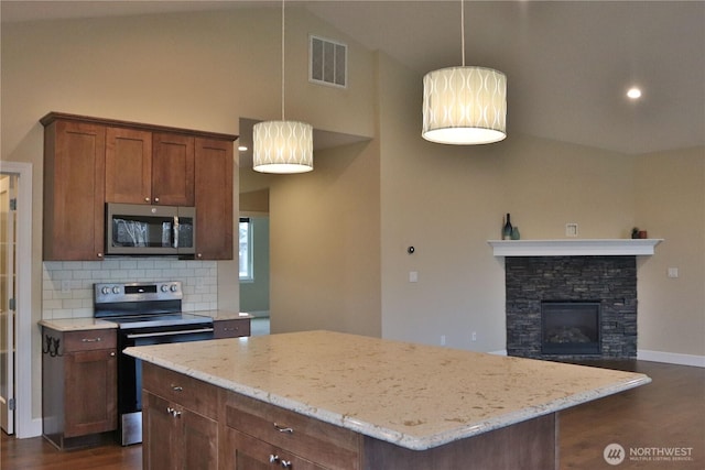 kitchen with visible vents, a center island, decorative backsplash, appliances with stainless steel finishes, and dark wood-style floors