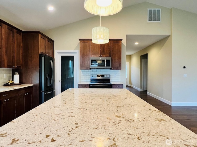 kitchen with visible vents, light stone counters, dark wood-style floors, stainless steel appliances, and baseboards