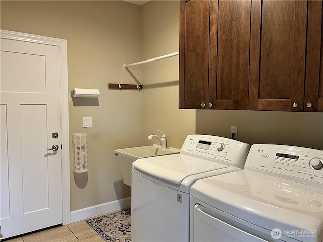 washroom featuring cabinet space, washing machine and dryer, baseboards, and a sink