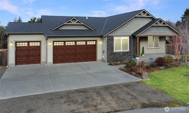 craftsman house with driveway, roof with shingles, a front lawn, stone siding, and a garage