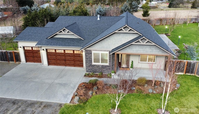 craftsman inspired home with a front lawn, fence, a garage, and driveway