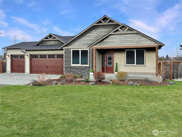 craftsman-style house featuring a garage, driveway, a front lawn, and fence