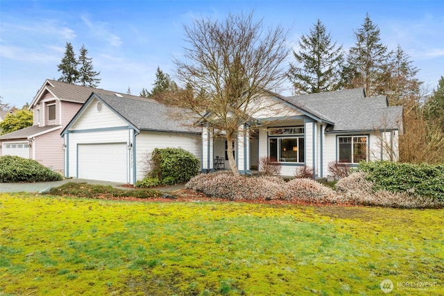 view of front of home featuring a garage, a front yard, and roof with shingles