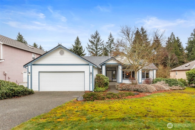 ranch-style home with a garage, aphalt driveway, and a front yard