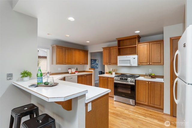 kitchen with light countertops, white appliances, and a sink