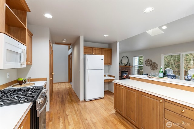 kitchen with white appliances, light wood-style flooring, light countertops, and recessed lighting