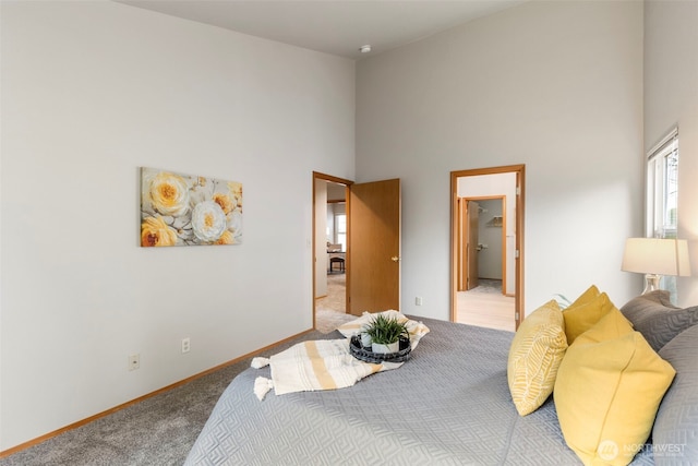 bedroom with a towering ceiling, baseboards, and carpet flooring