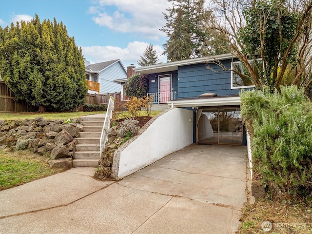 view of front of property with a carport, driveway, and fence