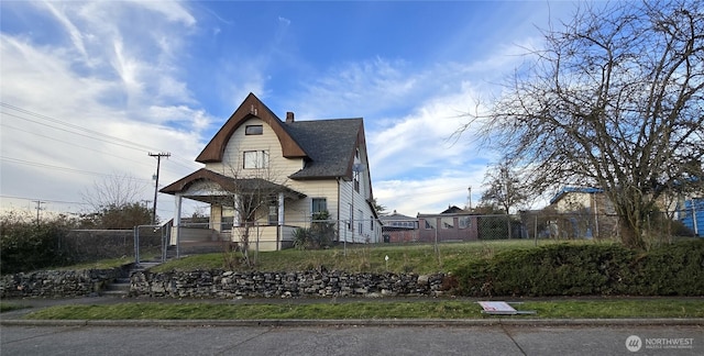 view of front of home with fence, covered porch, and a chimney