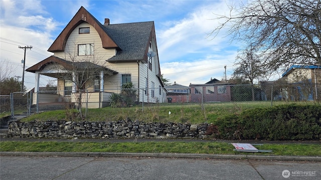 view of front of home featuring a gate, fence private yard, a chimney, and a shingled roof