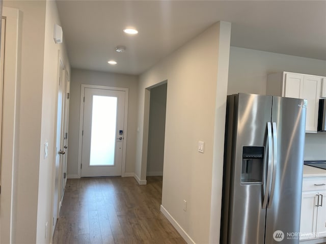 3601 Page St, Port Angeles, WA 98362 - kitchen with stainless steel fridge, wood finished floors, white cabinets, recessed lighting, and light countertops