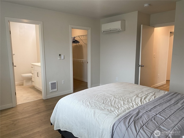 3601 Page St, Port Angeles, WA 98362 - bedroom featuring an AC wall unit, wood finished floors, a spacious closet, heating unit, and a closet