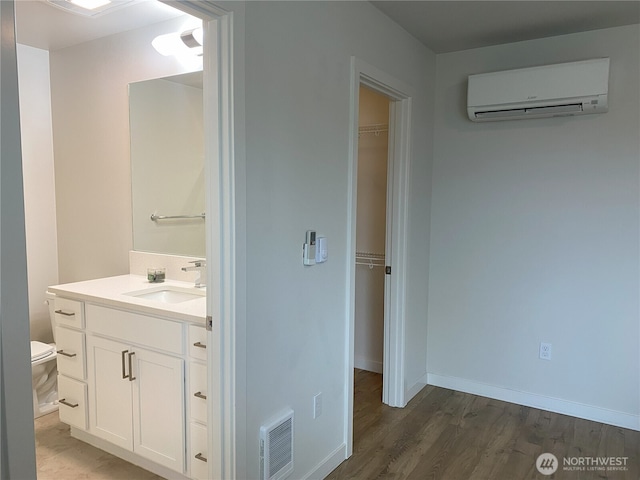 3601 Page St, Port Angeles, WA 98362 - bathroom featuring a wall mounted air conditioner, vanity, and wood finished floors