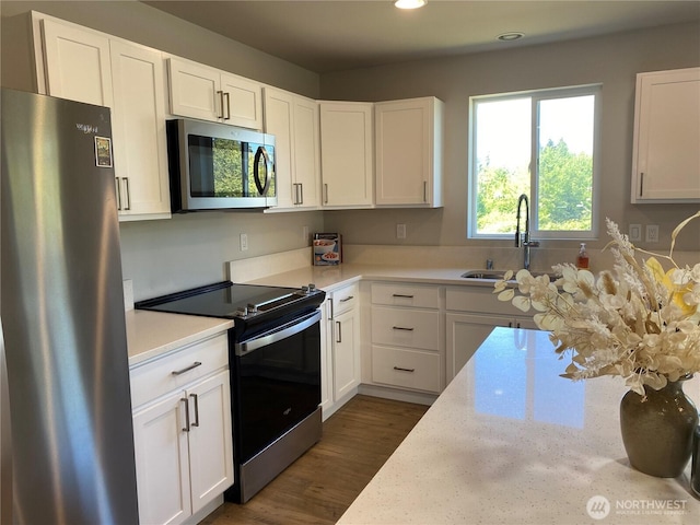 3601 Page St, Port Angeles, WA 98362 - kitchen with appliances with stainless steel finishes, white cabinets, dark wood-style flooring, recessed lighting, and light stone counters