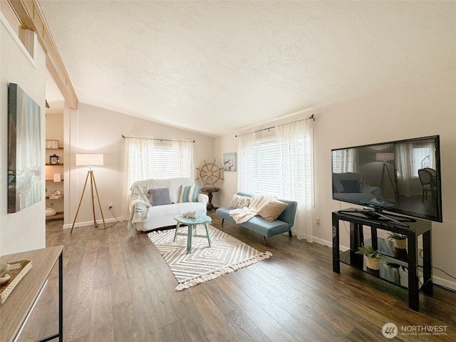 living room featuring vaulted ceiling, a textured ceiling, wood finished floors, and baseboards