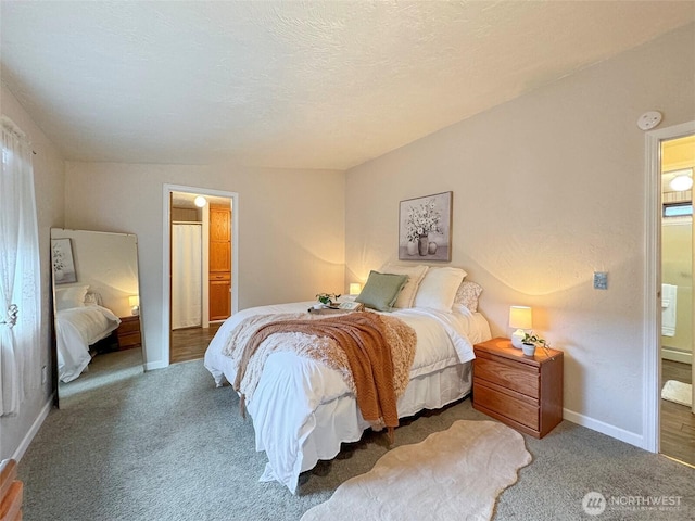 carpeted bedroom featuring baseboards and a textured ceiling