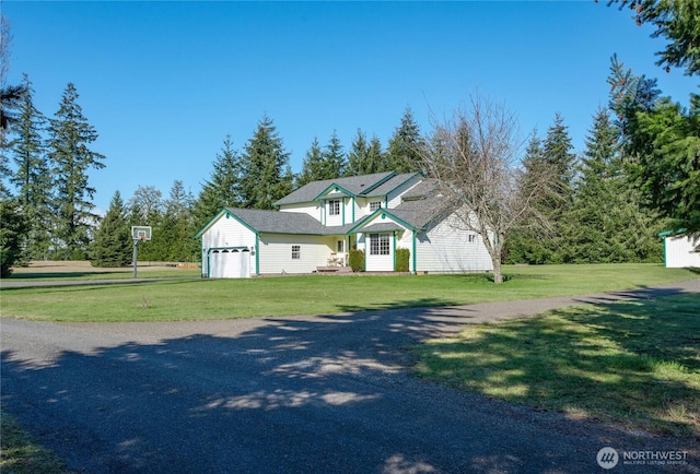 traditional home with a garage, a front yard, and driveway