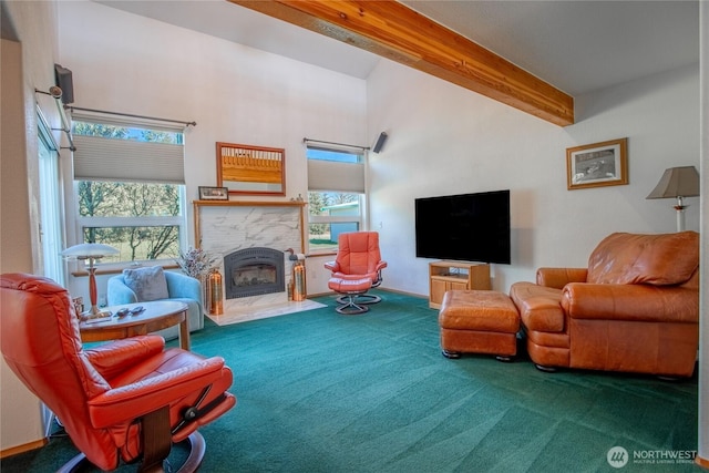 carpeted living area with a towering ceiling, a wealth of natural light, beam ceiling, and a stone fireplace