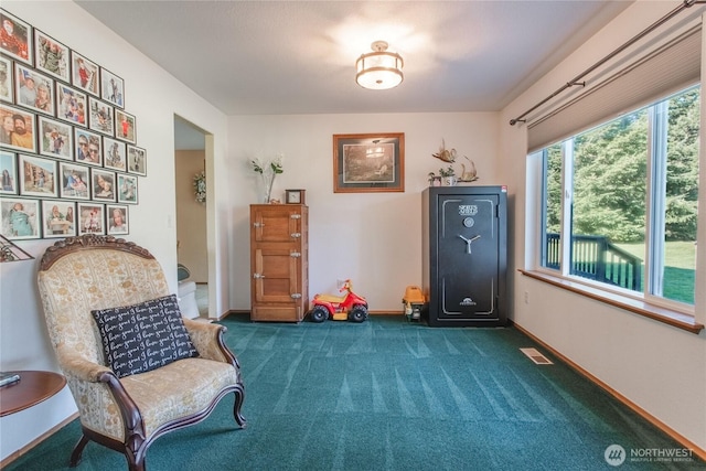 sitting room featuring baseboards, visible vents, and dark carpet