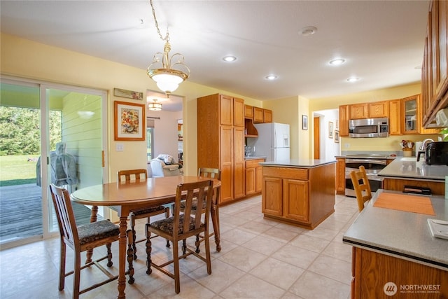 kitchen featuring a kitchen island, glass insert cabinets, appliances with stainless steel finishes, hanging light fixtures, and recessed lighting